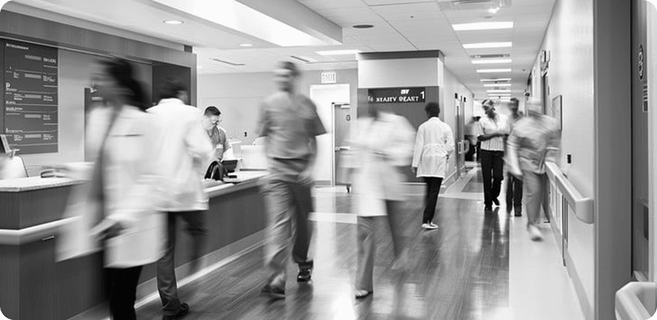 Clinic staff in motion behind a busy front desk, in black and white.